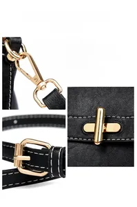 Detail of black pebbled leather texture, gold twist lock, and metal buckle on handbag