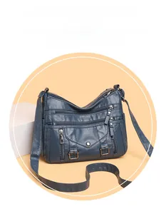 Detail of vintage blue multi-pocket crossbody bag with soft leather texture and metal zippers