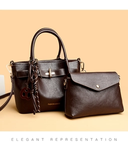 Detail of dark brown vintage faux leather handbag set with gold hardware and tassel decor