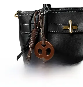 Detail of black leather bag featuring white contrast stitching and golden twist lock closure