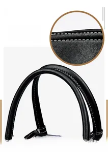 Close-up of black leather handbag with reinforced handle and white contrast stitching