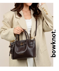 Detail of dark brown lychee pattern leather handbag with fashion text and shoulder strap