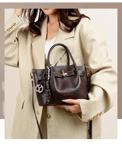 Detail of vintage dark brown tote bag showing gold logo and metal twist lock closure