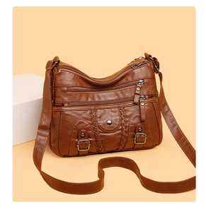 Détails d'un sac bandoulière marron en similicuir avec fermetures éclair et tressage