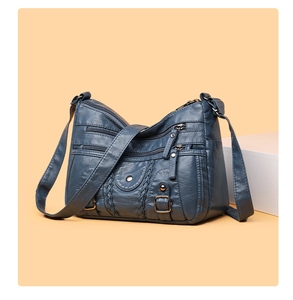 Détail du sac à bandoulière en cuir lavé bleu marine avec plusieurs poches zippées fonctionnelles