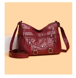 Detail view of burgundy multi-pocket crossbody bag with soft vintage leather texture