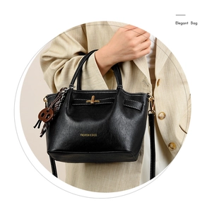 Detail of elegant black leather handbag featuring white stitching and gold twist-lock closure