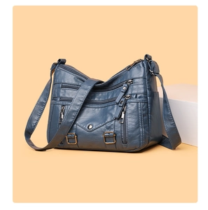 Detailed close-up of dark blue PU leather crossbody bag with multiple zipper pockets
