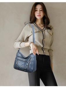 Detail of navy blue multi-pocket crossbody bag with high-quality soft leather texture