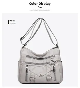 Macro view of light grey faux leather handbag showing multi-zipper pockets and litchi texture