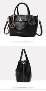 Detail of black PU leather handbag with white contrast stitching and gold lock buckle