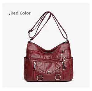 Detailed view of burgundy PU leather crossbody bag featuring multiple functional zippers