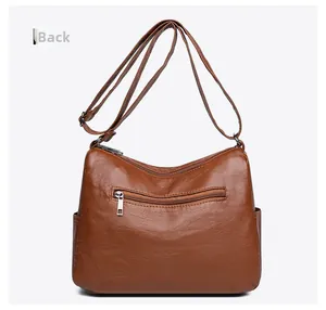 Vue arrière du sac bandoulière en cuir marron avec fermeture éclair et poches latérales