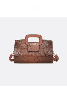 Detailansicht der dunkelbraunen Handtasche mit Krokodilprägung und goldener Hardware