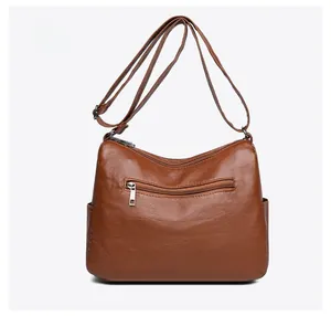Rear view of brown crossbody bag featuring a horizontal zipper pocket and adjustable strap