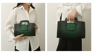 Detail der dunkelgrünen Handtasche mit Krokodilprägung, Vintage-Verlauf und Tragegriff