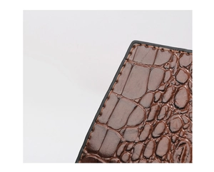 Detailaufnahme von dunkelbraunem Leder mit Kroko-Prägung und gleichmäßiger Naht