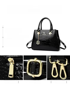 Detail of crocodile embossed leather texture with gold hardware on black handbag