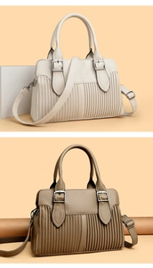 Detail of lychee textured leather bags showing vertical pleats and metal buckle hardware
