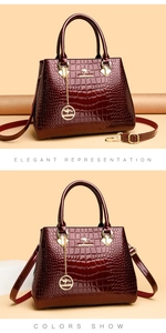 Macro shot of burgundy faux crocodile leather texture and gold kangaroo logo on the handbag