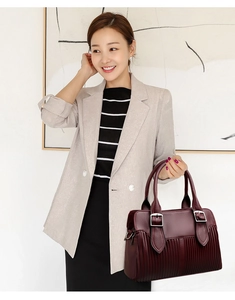 Close-up of wine red tote bag with pleated leather texture and silver metal rings