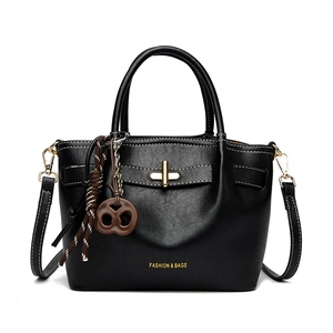 Retro black leather handbag with gold lock and woven rope charm on white background