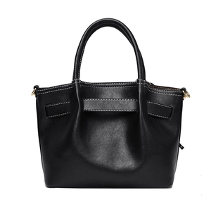 Minimalist black tote bag with white contrast stitching and golden hardware accents