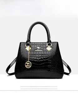 Detailed view of black crocodile pattern faux leather handbag with golden kangaroo pendant