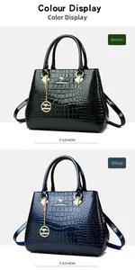 Detail of crocodile pattern faux leather handbag with gold metal hardware and kangaroo logo