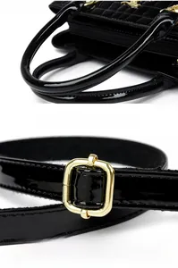 Detail of comfortable round handle and golden adjustable buckle on black patent bag