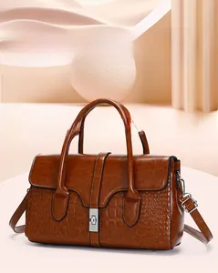 Détail du sac à main marron avec motif crocodile embossé et fermoir rotatif en métal