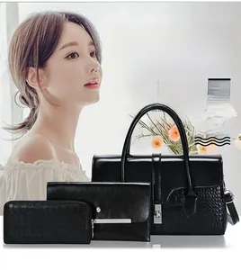 Détail d'un ensemble de sacs en cuir de vachette noir avec motif crocodile et fermoir doré