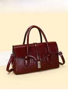 Détail du sac à main bordeaux avec texture crocodile et fermoir en métal doré