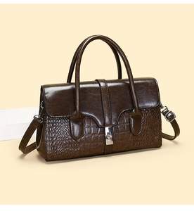 Vue détaillée du sac en cuir verni marron avec texture crocodile et fermoir argenté