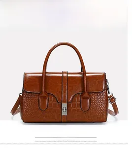 Détail du sac à main marron à motif crocodile en cuir verni avec fermoir doré