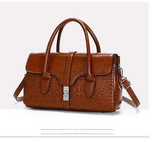 Détail d'un sac à main marron en cuir verni avec texture gaufrée et fermoir rotatif