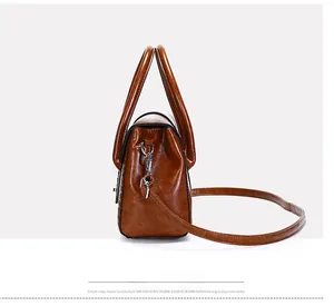 Vue détaillée du sac à main en cuir verni marron avec boucles en argent et texture rétro
