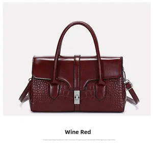 Détail du sac en cuir verni bordeaux avec texture crocodile et fermoir métallique argenté