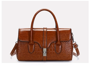 Détail du sac en cuir verni marron avec motif croco et fermoir rotatif argenté