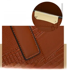 Detail of brown embossed leather tote with golden hardware and precision stitching