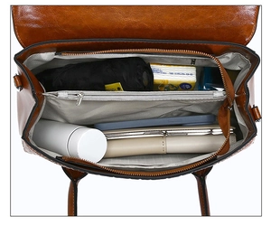 Vue intérieure du sac à main en cuir verni marron montrant les compartiments spacieux