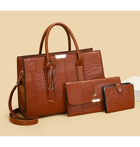 Close-up of vintage brown crocodile texture on 3-piece tote bag set with gold hardware