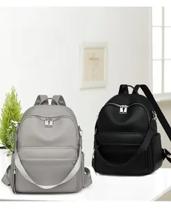 Detail showing high-quality lychee pattern leather texture and silver hardware on backpacks