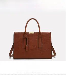 Front view of caramel crocodile pattern tote bag with gold hardware and top handles