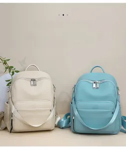 Close-up of minimalist leather backpacks in beige and light blue with lychee texture