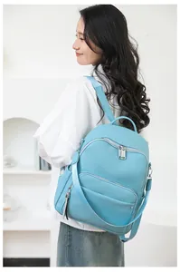 Close-up of light blue leather backpack featuring textured lychee grain and silver zippers