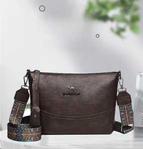 Detail der dunkelbraunen Leder-Eimertasche mit einem bestickten breiten Schultergurt