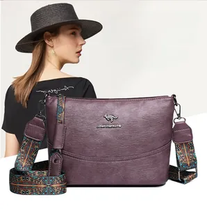 Detail einer lila Eimer-Tasche aus Leder mit Känguru-Logo und geometrischem Gurt