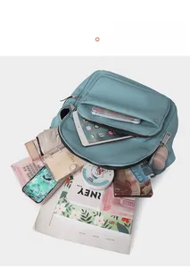 Detailed internal storage of light blue leather backpack with iPad and daily essentials
