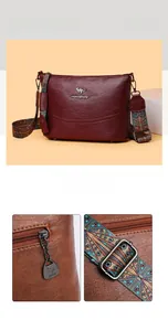 Detail der burgunderroten Leder-Eimertasche mit Markenlogo und Ethno-Gurt